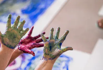 Drei Hände voller schleimiger Farbe.