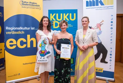 Teilnehmende Person und Vortragende posieren mit Zertifikat.