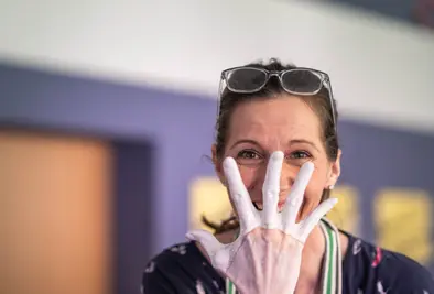 Nahaufnahme einer Person dessen Hand in Modelliergips getaucht wurde.