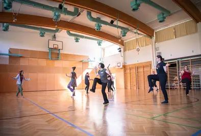 Teilnehmende springen in einem Turnsaal.