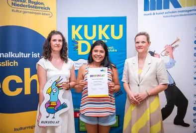 Teilnehmende Person und Vortragende posieren mit Zertifikat.