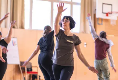 Teilnehmende tanzen im Turnsaal.