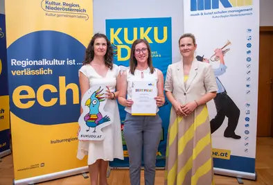 Teilnehmende Person und Vortragende posieren mit Zertifikat.