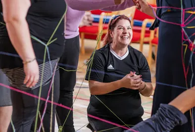 Teilnehmende in teilweise in Wolle eingewickelt.